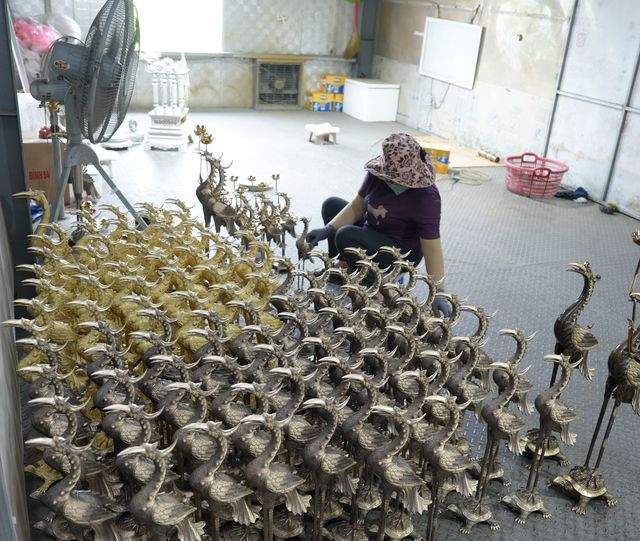Crane-and-tortoise pairs staged in rows before finishing