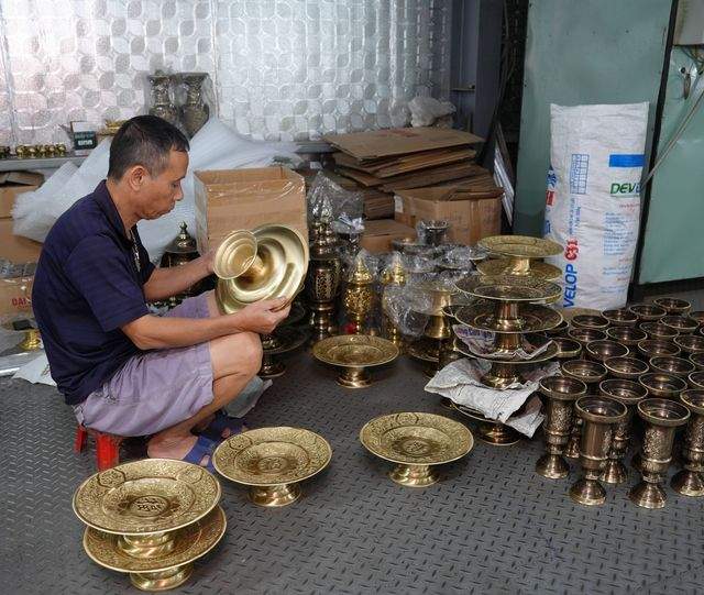 A worker checking incense bowls and offering trays and matching them into sets