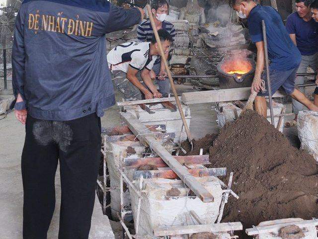 Sand moulds lined up in a trench while the crucible is carried to the pour