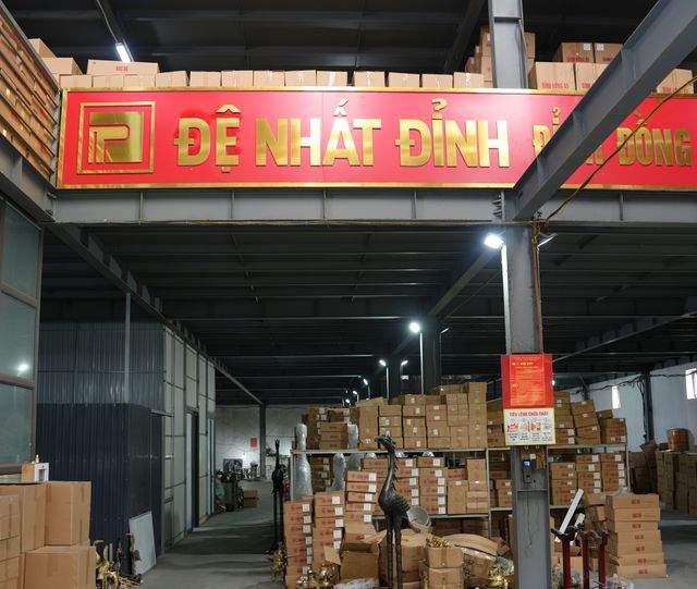 Finished bronze stacked in cartons in the dispatch bay of the De Nhat Dinh workshop, Nam Dinh